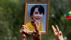 FILE - A person holds a picture of leader Aung San Suu Kyi as Myanmar citizens protest against the military coup in front of the UN office in Bangkok, Thailand Feb. 22, 2021.