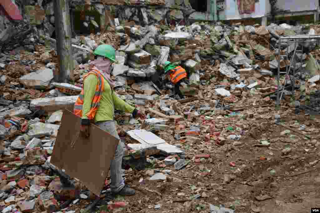 ស្រ្តី​ជា​កម្មការីនី​សំណង់​ ធ្វើការ​ក្នុង​គម្រោង​វាយកម្ទេច​អគារប៊ូឌីញ​ រាជធានីភ្នំពេញ​ នាថ្ងៃទី៣ ខែសីហា​ ឆ្នាំ​២០១៧។ (រ៉ាវី សុភារ័ត្ន/VOA)