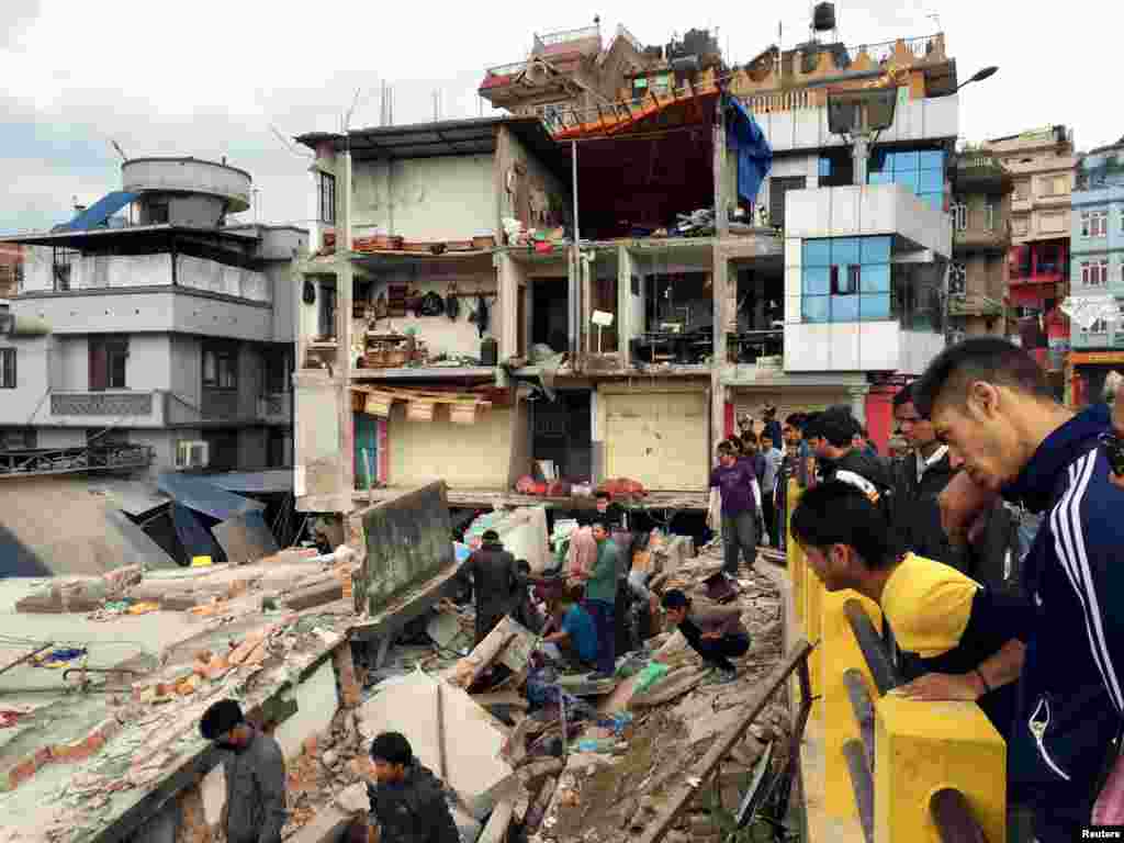 People survey a site damaged by an earthquake, in Kathmandu, Nepal, April 25, 2015. 