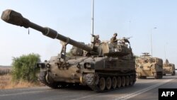 Konvoi tentara Israel bergerak di lokasi yang dirahasiakan yang berbatasan dengan Jalur Gaza hari Minggu, 8 Oktober 2023.