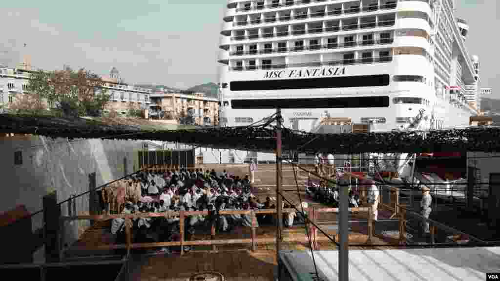 Les migrants attendent de débarquer du &quot;Siem Pilot&quot; à Messine, Sicile, Italie (Nicolas Pinault / VOA)