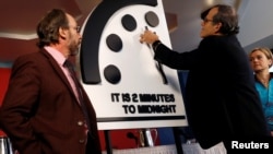 Members of the Bulletin of the Atomic Scientists, (L-R), Lawrence Krauss, Robert Rosner and Sharon Squassoni move the 'Doomsday Clock' hands to two minutes until midnight at a news conference in Washington, Jan. 25, 2018. (REUTERS/Leah Millis)