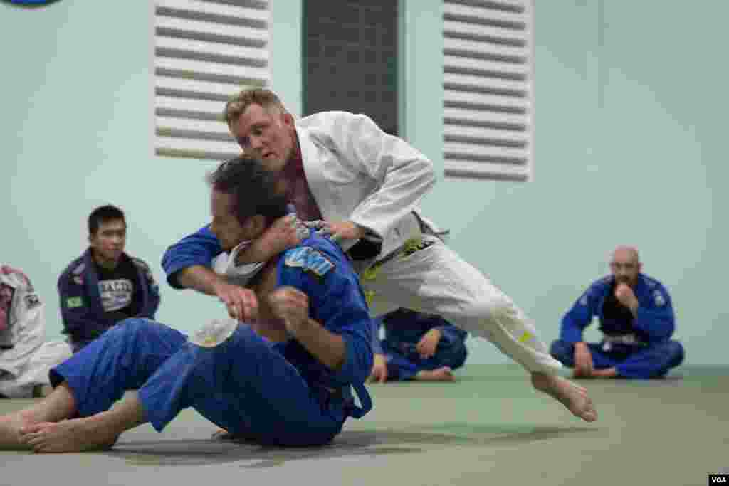 Chris Haueter (middle in white), one of the well-known BJJ trainers, trains a group of expats at the Olympic Stadium during a short seminar, in Phnom Penh, on February 22, 2016. (Neou Vannarin/VOA Khmer)