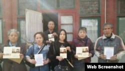 访民在赵紫阳故居房间外手握纪念卡合影（博讯图片） 