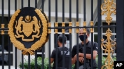 Police guard the back entrance at the national palace in Kuala Lumpur, Malaysia, Aug. 19, 2021.