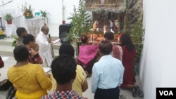 Pemasangan lilin di kandang natal dalam kegiatan misa malam natal di gereja Katolik Kristus Raja stasi Sidera, Kabupaten Sigi, Sulawesi Tengah (24/12). Foto : VOA/Yoanes Litha