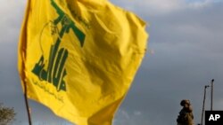 FILE - A soldier stands guard near a Hezbollah flag, near the Lebanese southern border village of Mays al-Jabal, Lebanon, Dec. 13, 2018.