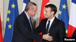 French President Emmanuel Macron greets Turkish President Recep Tayyip Erdogan during a joint news conference at the Elysee Palace in Paris, France, Jan. 5, 2018.
