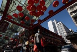 A Chinese couple wearing face masks walks amid Chinese Lunar New Year decorations in Kuala Lumpur, Malaysia, Feb. 7, 2021.