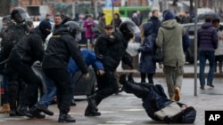 Belarus police push a woman down while detaining an activist during an opposition rally in Minsk, Belarus, March 25, 2017. 