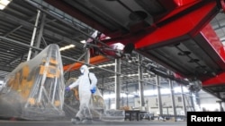 A worker in protective suit disinfects a factory before it resumes operation on February 10 following an extended Lunar New Year holiday caused by the novel coronavirus outbreak, in Lianyungang, Jiangsu province, China February 9, 2020. cnsphoto via…
