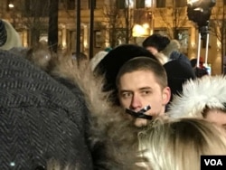 A man in the crowd at a Moscow vigil for those who died in a shopping mall blaze March 25 in the Siberian city of Kemerovo offers an indication of protest, March 27, 2018. Opposition figure Alexei Navalny appeared earlier at the vigil, and there were chants for Russian President Vladimir Putin to resign. Police were keeping a close watch. (J. Dettmer/VOA)
