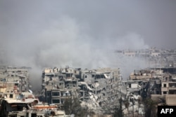Smoke billows following Syrian government bombardment on the rebel-held besieged town of Harasta, in the Eastern Ghouta region on the outskirts of Damascus, March 12, 2018.