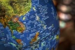 FILE - In this July 13, 2018, a globe shows the islands on the South China Sea with nine-dash line claims under Chinese territory on display at a bookstore in Beijing, China.
