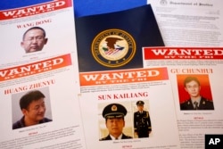 FILE - Press materials are displayed on a table of the Justice Department in Washington, before an announcement that a U.S. grand jury charged five Chinese hackers with economic espionage and trade secret theft, the first-of-its-kind criminal charges against Chinese military officials in an international cyber espionage case, May 19, 2014.