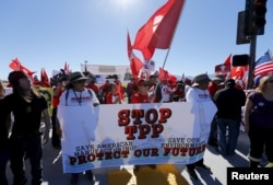 FILE - Protesters line one side of a roadway leading to Sunnylands where U.S. President Obama prepares to host leaders from Southeast Asia at the ASEAN Summit in Rancho Mirage, California, Feb. 15, 2016.