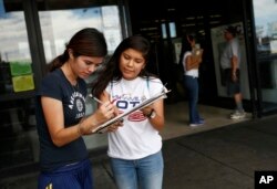 Fabiola Vejar, right, registers Stephanie Cardenas to vote in front of a Latino supermarket in Las Vegas in June 2016. (AP)