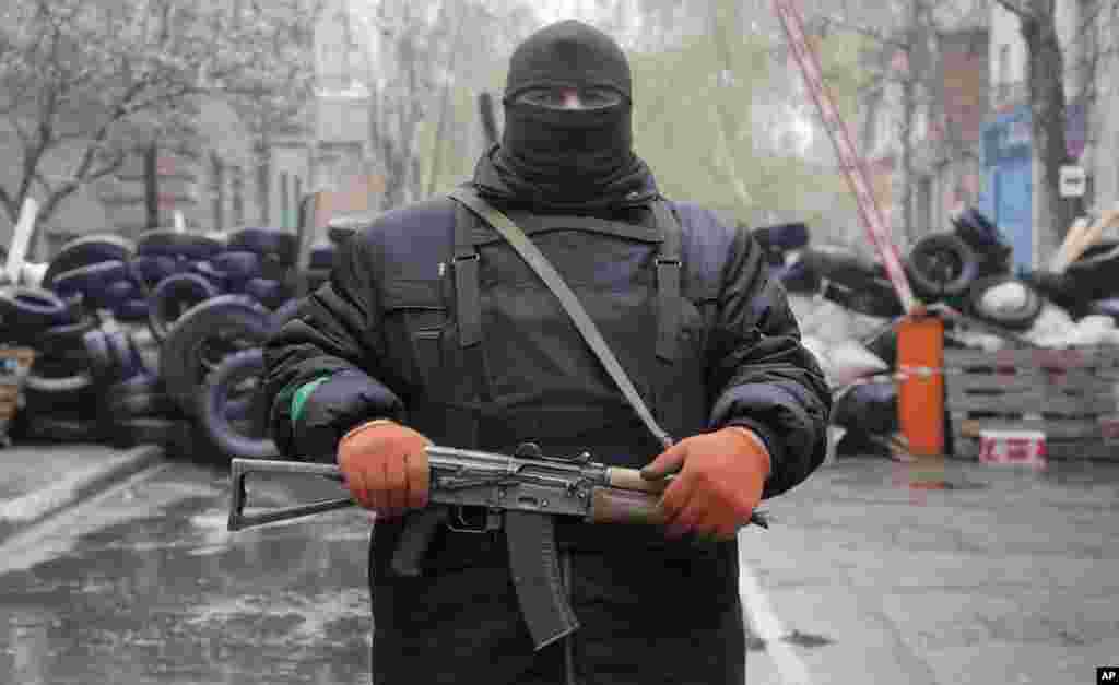 A pro-Russian gunman stands guard at a police station that was seized by pro-Russian militants, in the eastern Ukraine town of Slovyansk, April 13, 2014.&nbsp;