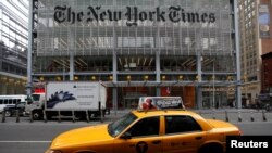 FILE - A taxi passes by in front of The New York Times head office in New York.