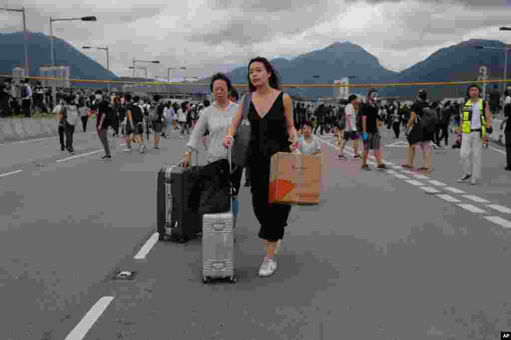 抗议者堵塞机场外的一条公路。乘客步行前往机场。(2019年9月1日)