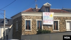 A banner outside Paris thanking health care workers and others on the frontlines of the coronavirus battle. (Lisa Bryant/VOA)