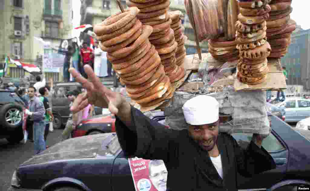 A bread seller in Tahrir square, making a victory sign.