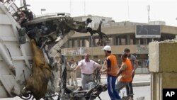 Petugas membersihkan puing-puing bekas ledakan bom mobil di Baghdad (19/4). 