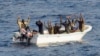 Suspected pirates keep their hands in the air as directed by sailors aboard the guided-missile cruiser USS Vella Gulf (CG 72) (not shown), in the Gulf of Aden, February 11, 2009.