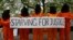 Protesters depicting detainees of the US detention facility at Guantanamo Bay, Cuba, hold a banner, during a demonstration outside the US embassy in central London, May 18, 2013.