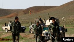 FILE - Afghan National Army soldiers (ANA) check the road before an operation at the Mir Abadi village of Adraskan district of Herat province, April 4, 2014. 