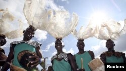 FILE - Performers wear traditional tribal clothings poses before Pope Francis' arrives at Kololo Air strip for a meeting with youths in Kampala, Uganda, Nov. 28, 2015. 