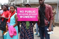 A protestor carries a sign during Friday's women rights demonstration in Malawi. (Lameck Masina/VOA)
