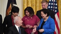 President Joe Biden hands a pen to Sen. Mazie Hirono, D-Hawaii, after signing the COVID-19 Hate Crimes Act, in the East Room of the White House in Washington, May 20, 2021.