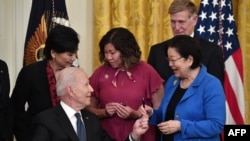 Predsjednik Joe Biden predaje olovku senatorki Mazie Hirono, D-Hawaii, nakon potpisivanja zakona o zločinima iz mržnje, u Istočnoj sobi Bijele kuće u Washingtonu, 20. maj 2021. godine.