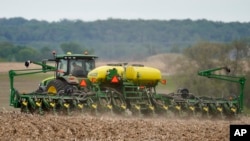 FILE - A farmer plants soybeans in a field in Springfield, Neb., May 23, 2019. 