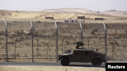 FILE - An armored Israeli military vehicle drives along Israel's border with Egypt's Sinai peninsula in January 2014. 