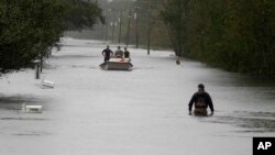 Seorang anggota Garda Pantai AS berjalan mengarungi banjir di Mill Creek Road setelah Badai Florence melanda Newport, North Carolina, 15 September 2018.