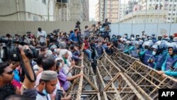 Activists stand separated from the police with a barrier during a protest against the Digital Security Act, in Dhaka, March 3, 2021.