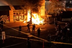 Protesters watch a structure fire set following the police shooting of a man on April 17, 2021, in Portland, Oregon.