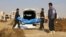 FILE - This frame grab from a video provided on Nov. 22, 2018, shows Syrian workers of a Raqqa group carrying human remains at the site of a mass grave believed to contain the bodies of civilians and Islamic State militants, in Raqqa. 