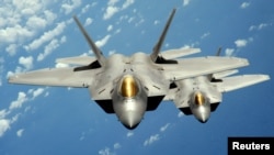 FILE - Two U.S. Air Force F-22 Raptor stealth jet fighters fly near Andersen Air Force Base in this handout photo dated Aug. 4, 2010. 