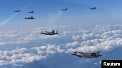 U.S. Marine Corps F-35B fighter jets (front) and South Korean air Force's F-15K fly over South Korea during a joint military drill, South Korea, Aug. 31, 2017.