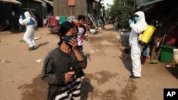 ពលរដ្ឋនៅក្នុងសង្កាត់ស្ទឹងមានជ័យដើរចេញពីកន្លែង ដែលបុគ្គលិកប្រចាំអង្គការមូលនិធិកុមារកម្ពុជា (CCF) កំពុងបាញ់ថ្នាំសម្លាប់មេរោគដើម្បីជួយទប់ស្កាត់ការឆ្លងរាលដាលនៃវីរុសកូរ៉ូណាប្រភេទថ្មី នៅតំបន់ស្ទឹងមានជ័យ ជាយរាជធានីភ្នំពេញ ថ្ងៃទី២៤ ខែមីនា ឆ្នាំ២០២០។ 