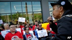 Michelle Dottin, a driver and stewart with the Independent Drivers Union Guild, speaks at a rally outside Uber and Lyft offices, calling for "fair pay for all drivers," May 8, 2019, in New York. 