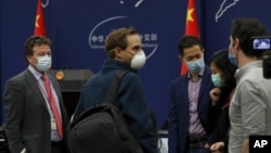 2020年3月18日《纽约时报》驻北京记者迈尔斯(左)出席中国外交部每日简报会后与其他外国记者交谈。