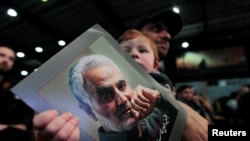 Seorang anak membawa foto mendiang Qassem Soleimani, dalam peringatan setahun meninggalnya Komandan Garda Revolusi Iran tersebut di Beirut, Lebanon, 16 Februari 2020. (Foto: dok).