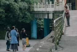 饰演秀英阿嬷的陈淑芳（右）向穿着青蓝色大衣的死去丈夫的情人（丁宁饰）喊了一声：“蔡小姐！”（威视电影授权提供）