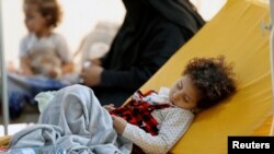A girl sleeps on a bed at a cholera treatment center in Sanaa, Yemen, Aug. 4, 2018.