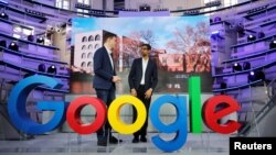 Google CEO Sundar Pichai and Philipp Justus, Google Vice President for Central Europe and German-speaking Countries, chat behind a Google logo during the opening of a new Google office in Berlin, Germany, Jan. 22, 2019.