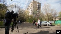A cameraman films a view of the building where homemade explosives were found in an apartment, in Moscow, Russia, Oct. 12, 2015.